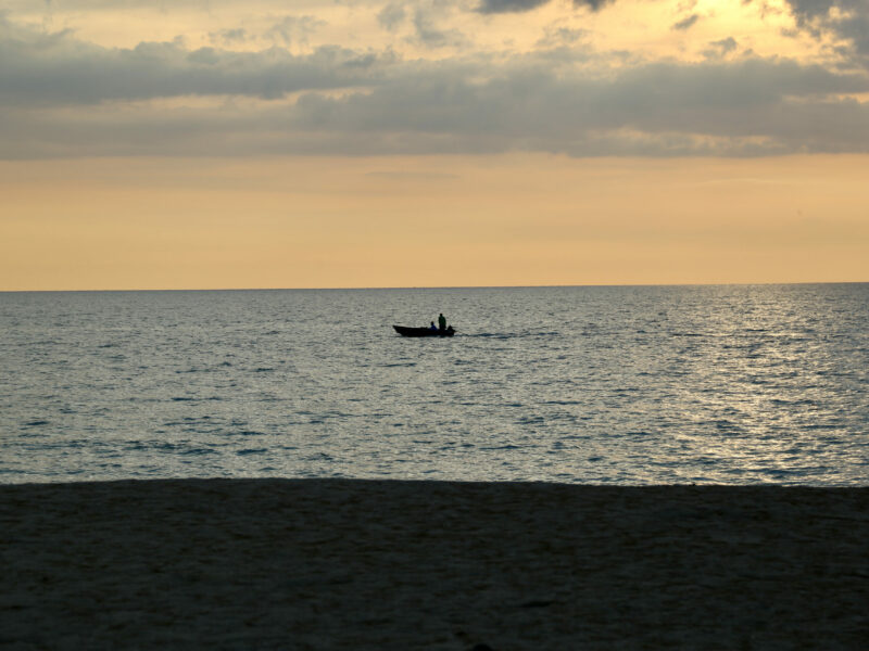 En fiskare stävar hemåt i solnedgången