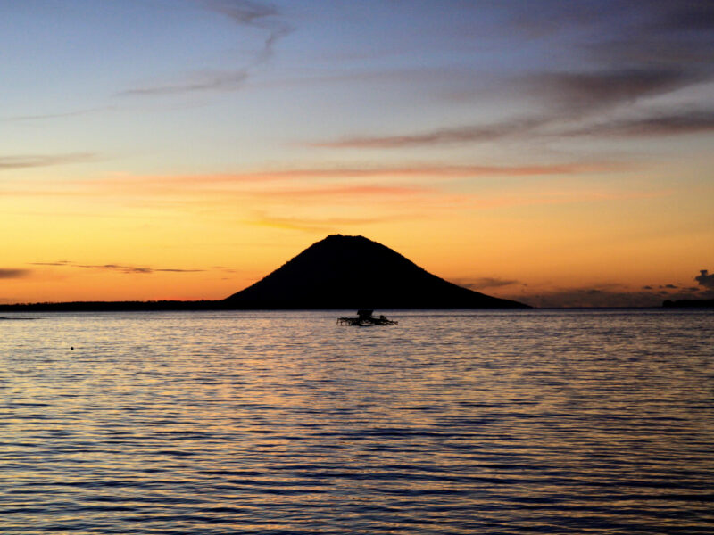 Pulau Siladen utgör en härlig vy från Kima Bajo Resorts strand när solen går ner